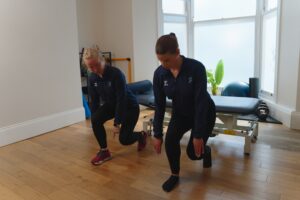 Physiotherapist and patient with hamstring pain doing exercise.