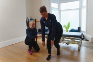 Runner performing back pan exercise with physiotherapist at prosport in huddersfield.